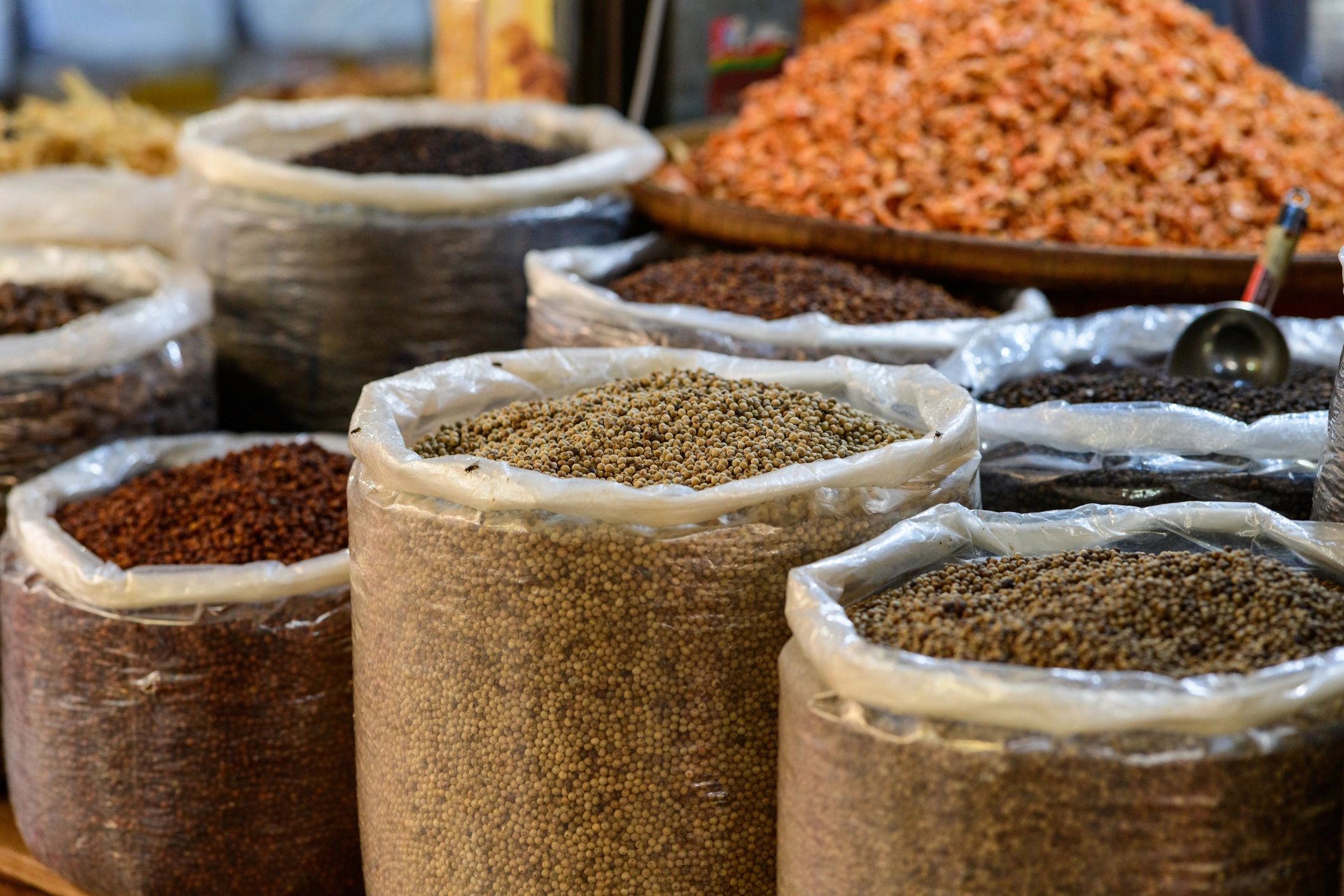 Bulk spices and peppercorns displayed in sacks at a market in Kampot, Cambodia
